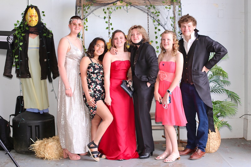 Seven students standing together posing at spring prom.